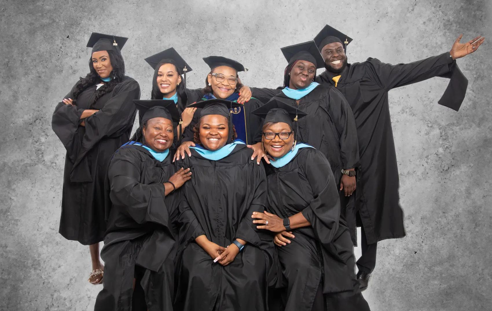 Voorhees University graduates in caps and gowns, smiling together